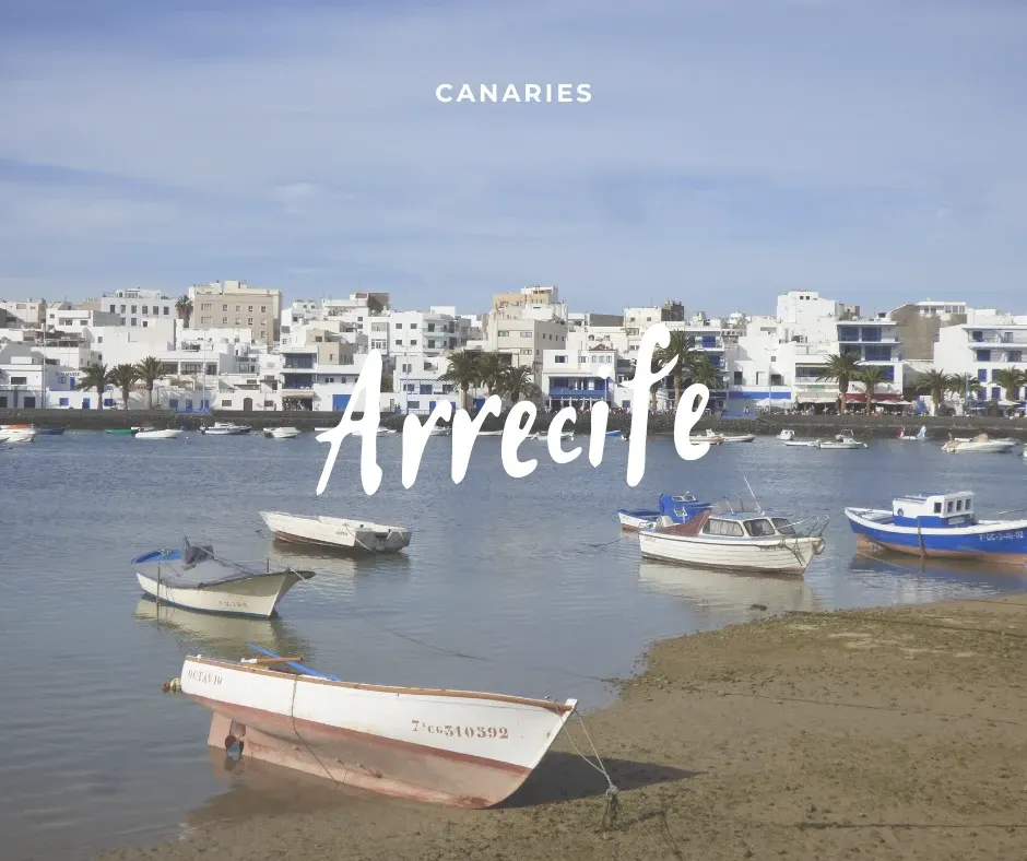 Barque blanche échouée devant les maisons blanches d'Arrecife