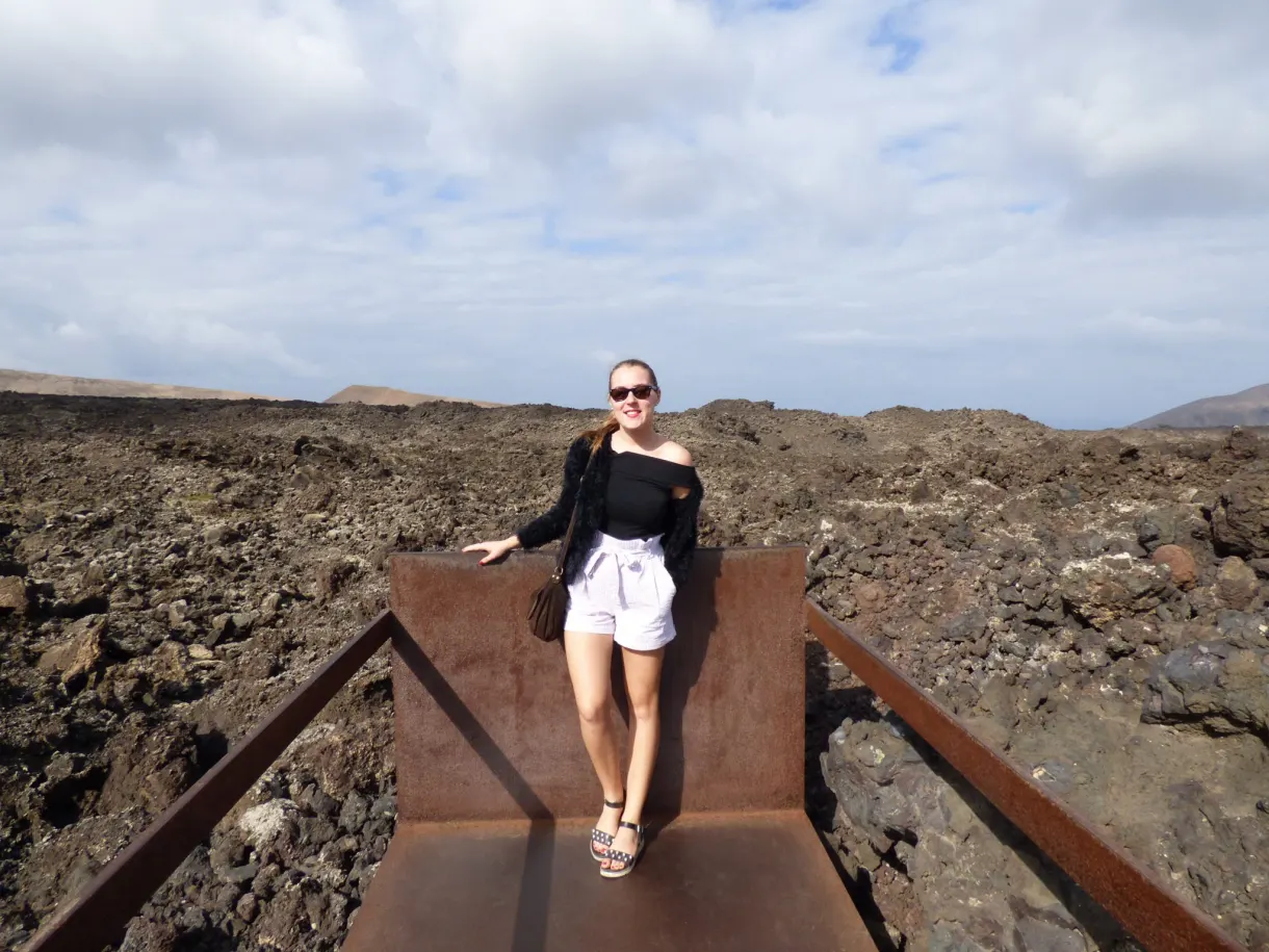 Femme posant sur la passerelle rouillée du sentier de lave