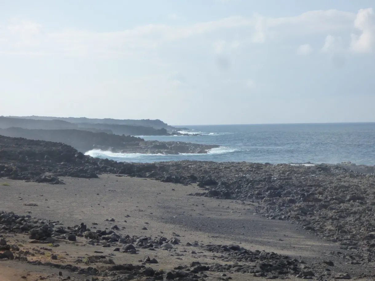 Littoral de lave grise bordé d'un océan laiteux