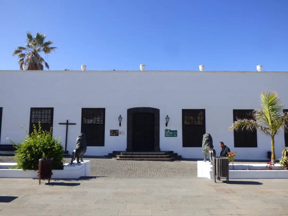 Palais blanc et lions de bronze sur la place pavée de Teguise
