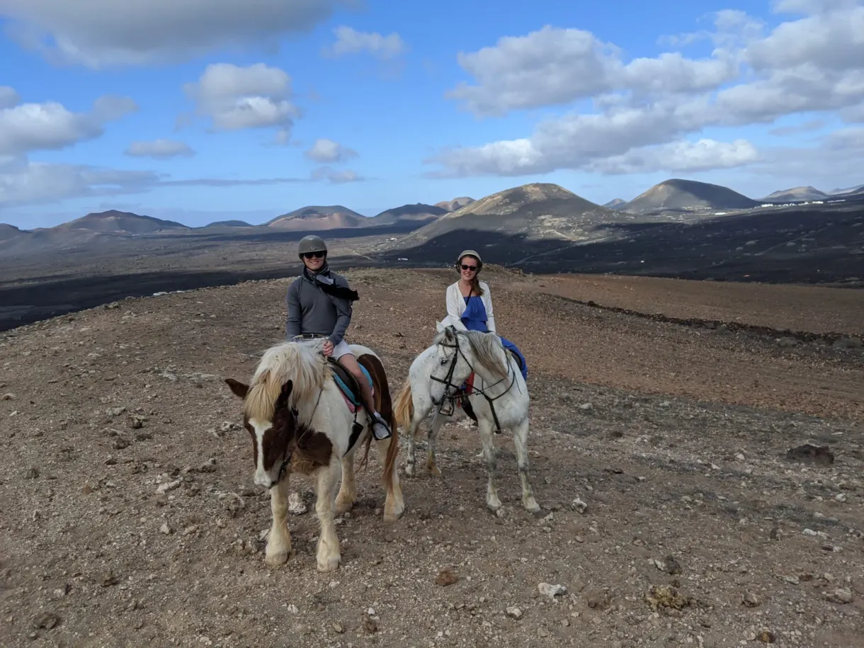Deux cavaliers côte à côte devant la chaîne de volcans