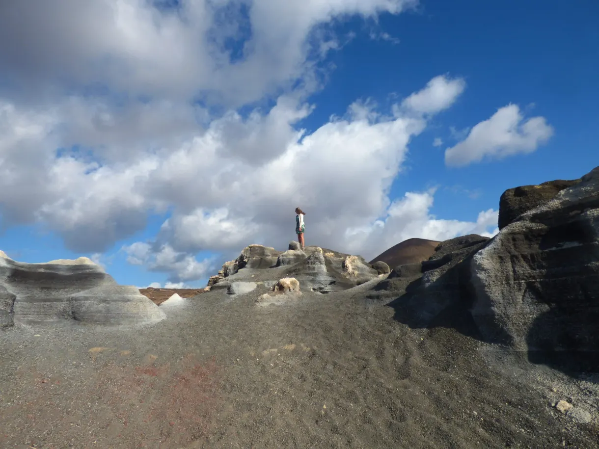 Marcheur minuscule sur une plateforme de roche claire érodée