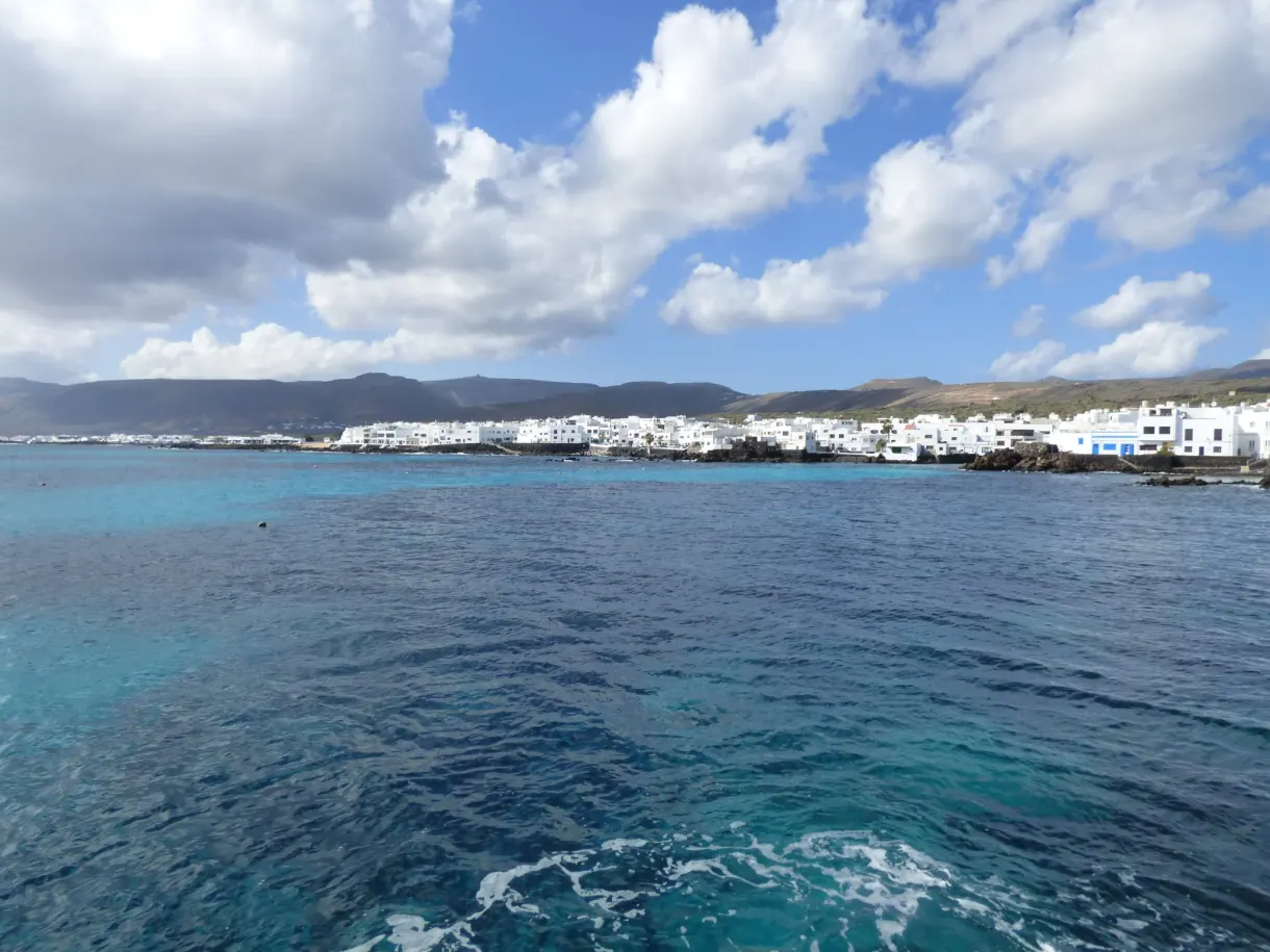 Lagune turquoise ourlée d'écume devant le village blanc