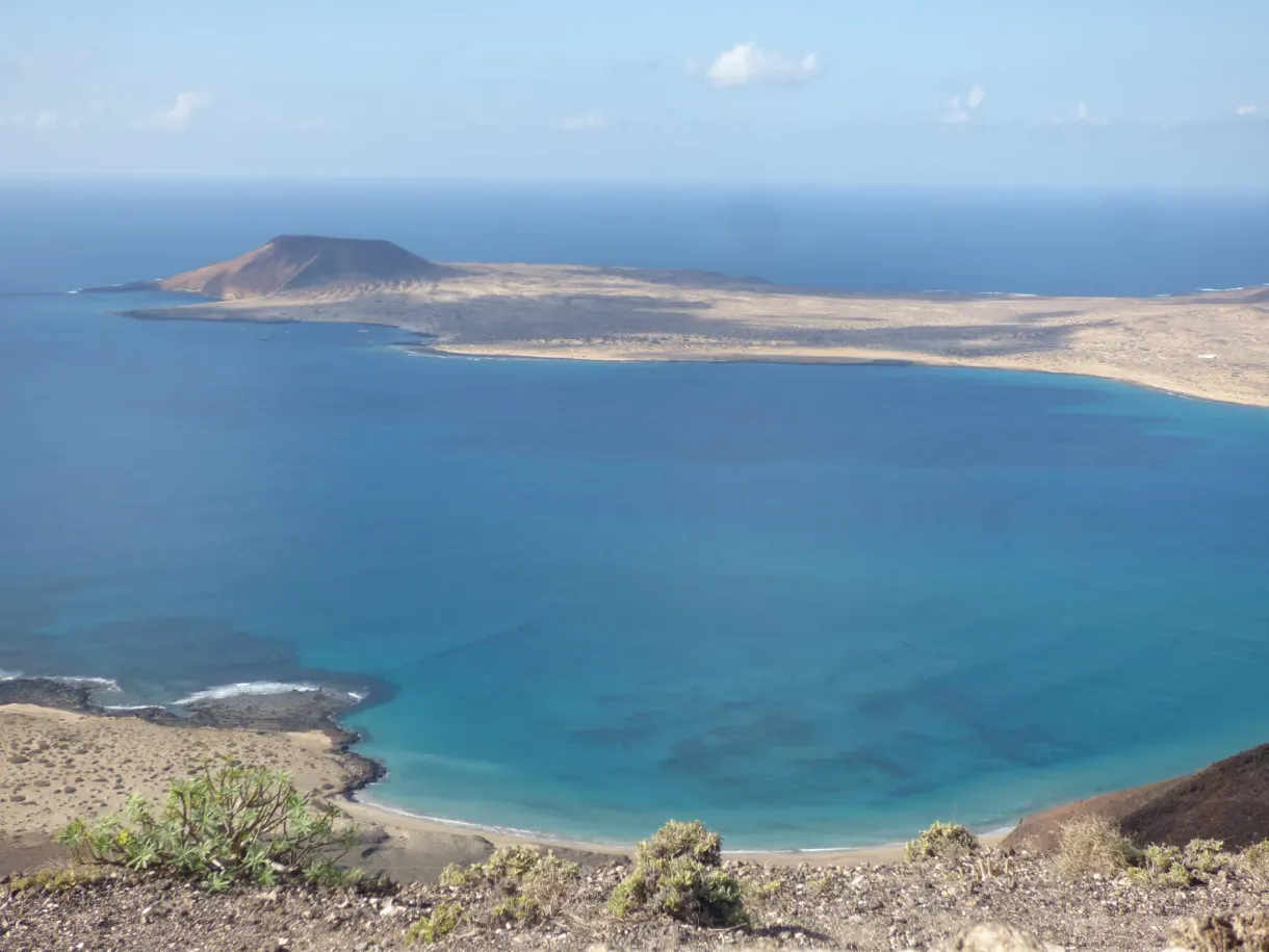 Colline brune de l'île cernée d'une lagune turquoise
