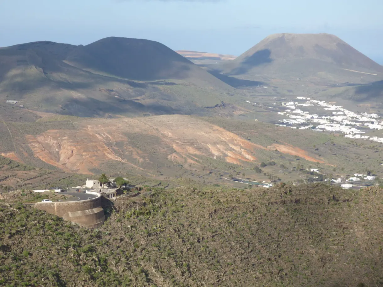 Cône volcanique dominant les maisons blanches de la vallée