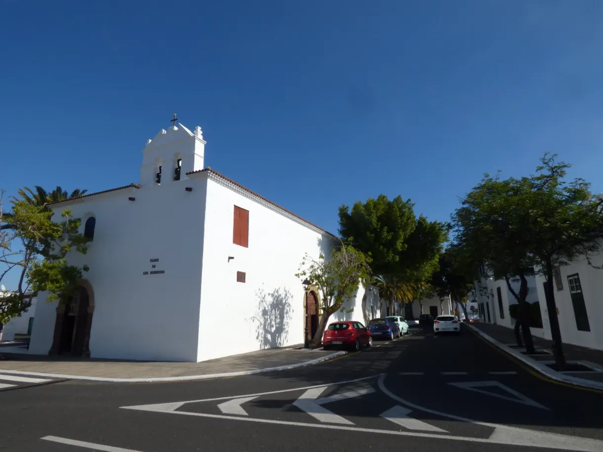 Église blanche à clocher-mur au coin d'une rue déserte