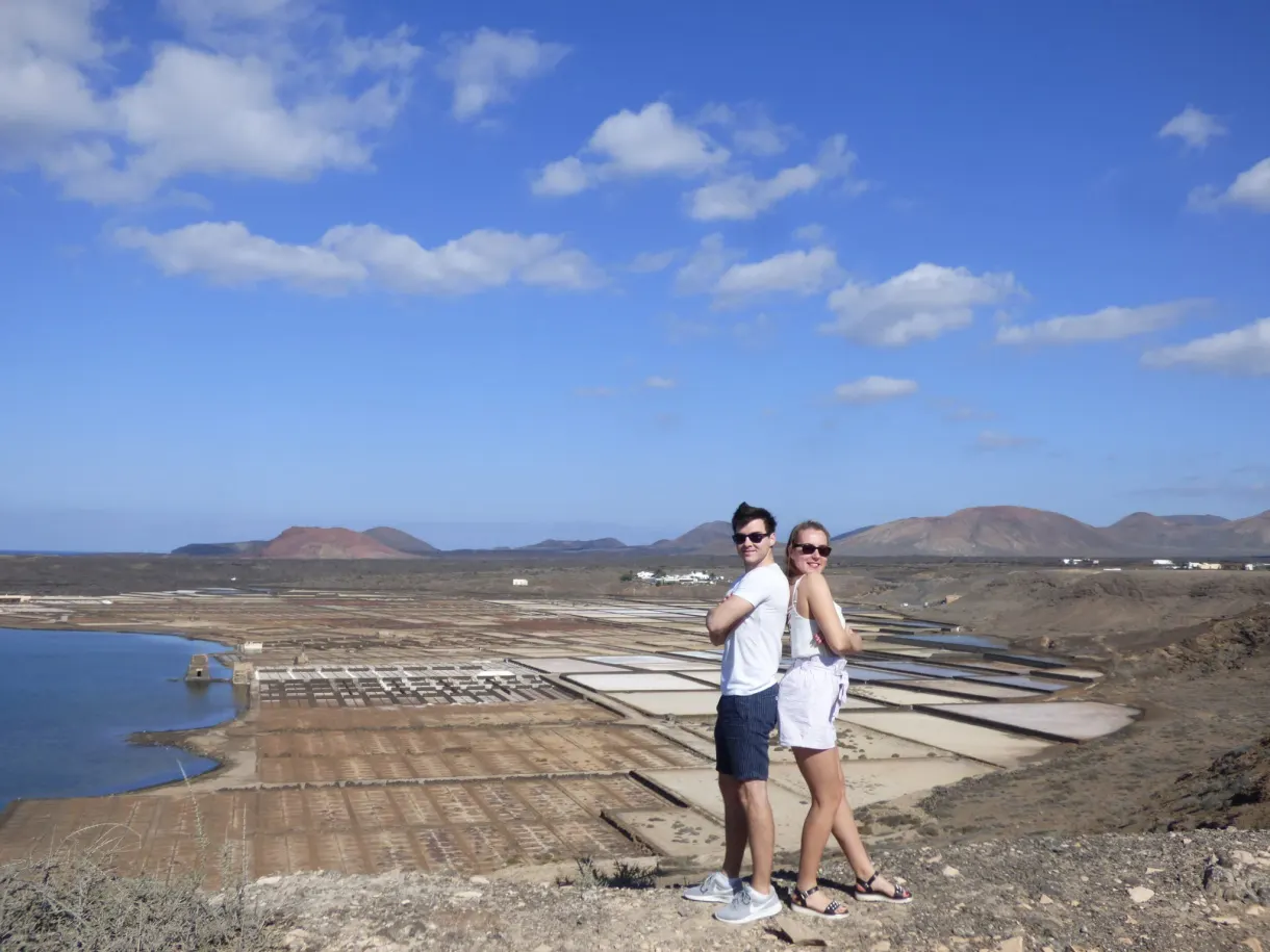 Couple posant devant les salines et les volcans à l'horizon