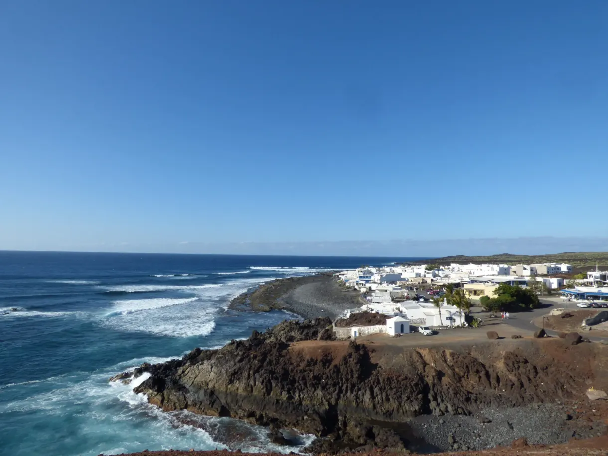 Village blanc sur la pointe rocheuse battue par les vagues