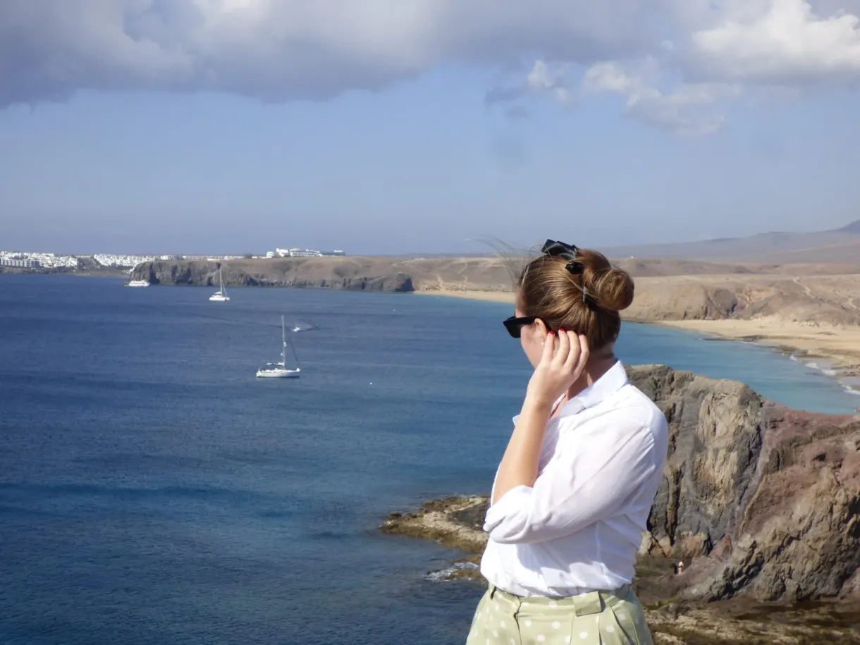 Femme en chemise blanche regardant la baie et les voiliers