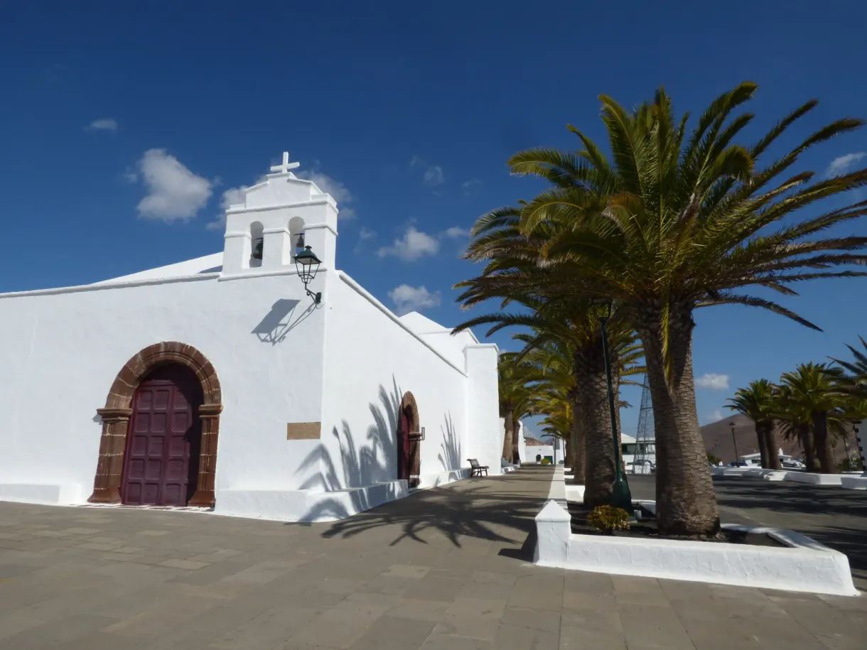 Église blanche et palmiers sur la place du village de Femés