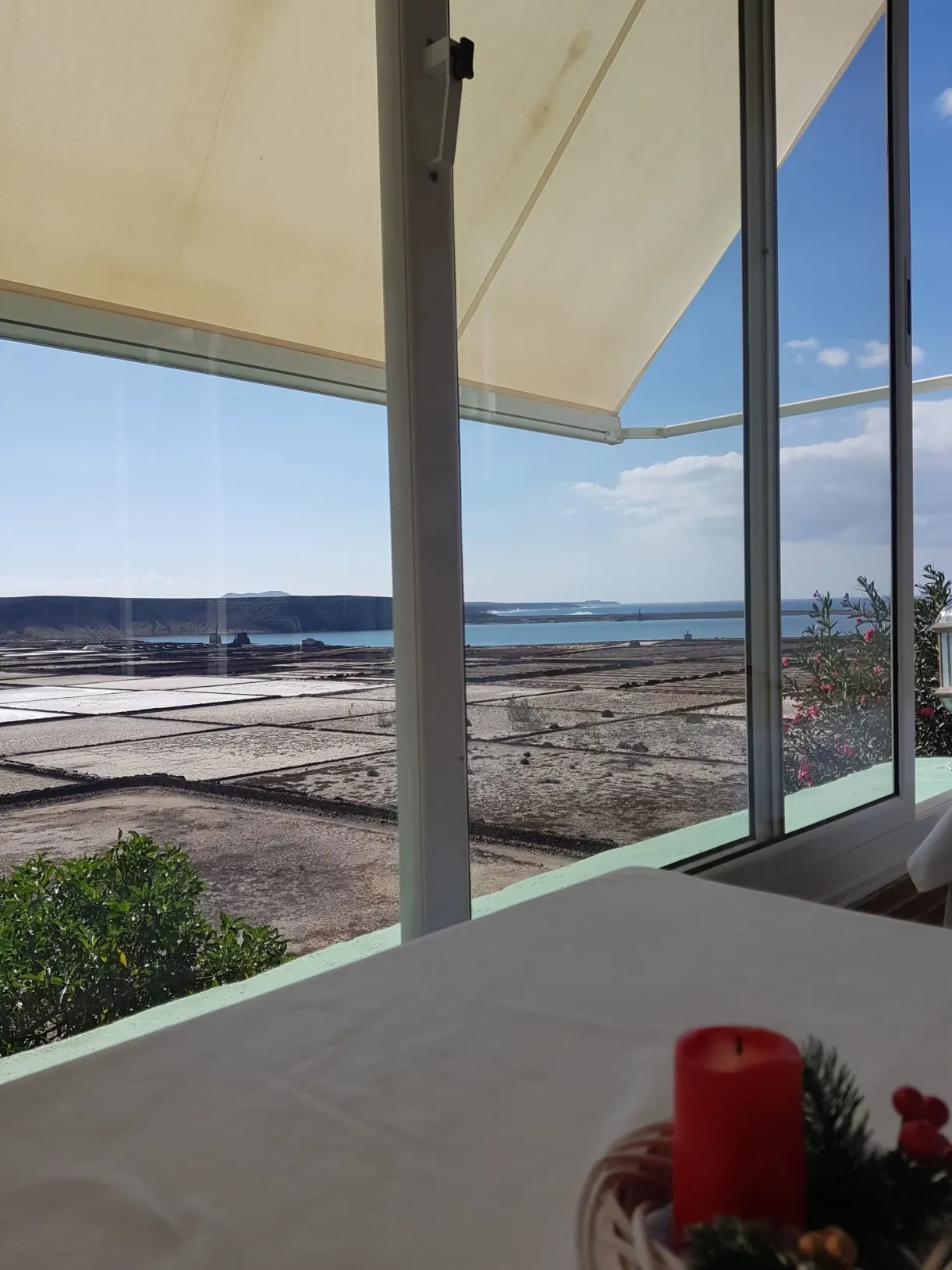 Table dressée avec bougie rouge devant la baie vitrée