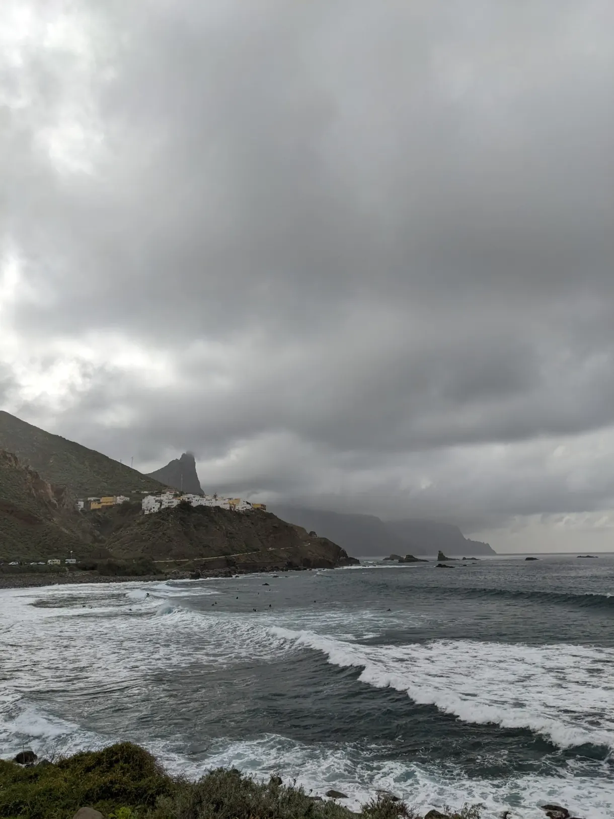 Vagues déferlant sur une plage sauvage sous un ciel gris