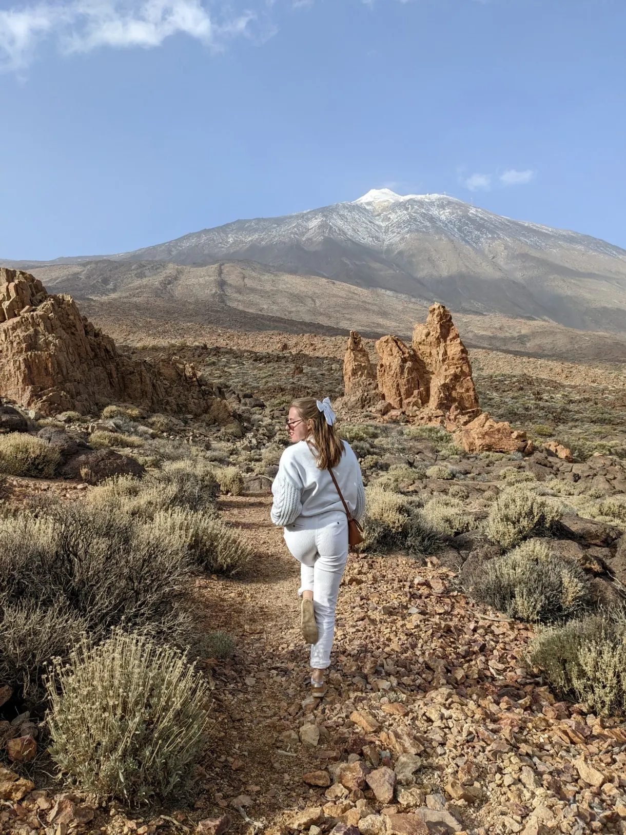 Walker on a stony trail heading towards the volcano