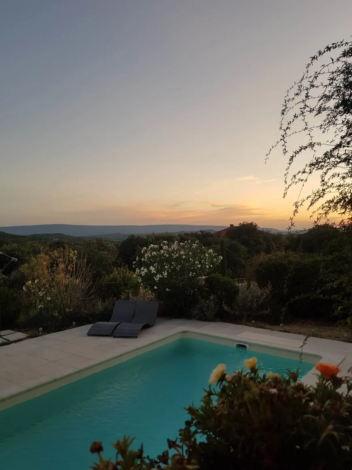Lone sun lounger at the edge of the pool under an orange sky