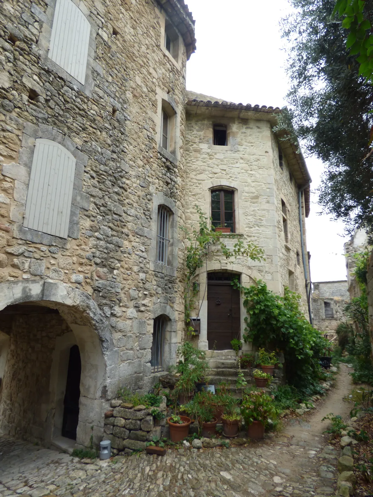 Stone house with a vaulted porch and flower pots