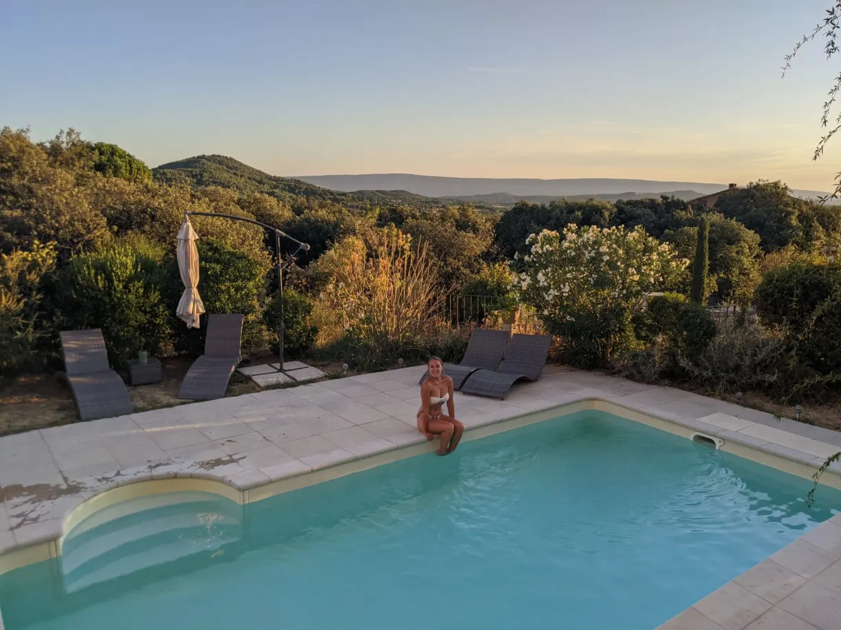 Woman sitting at the edge of the pool at sunset