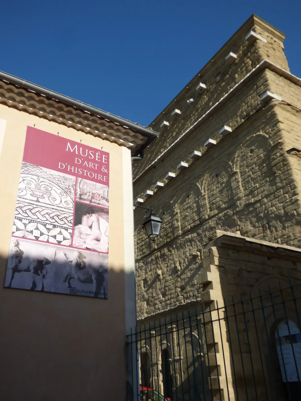 Affiche du musée d'art et d'histoire sur une façade de pierre