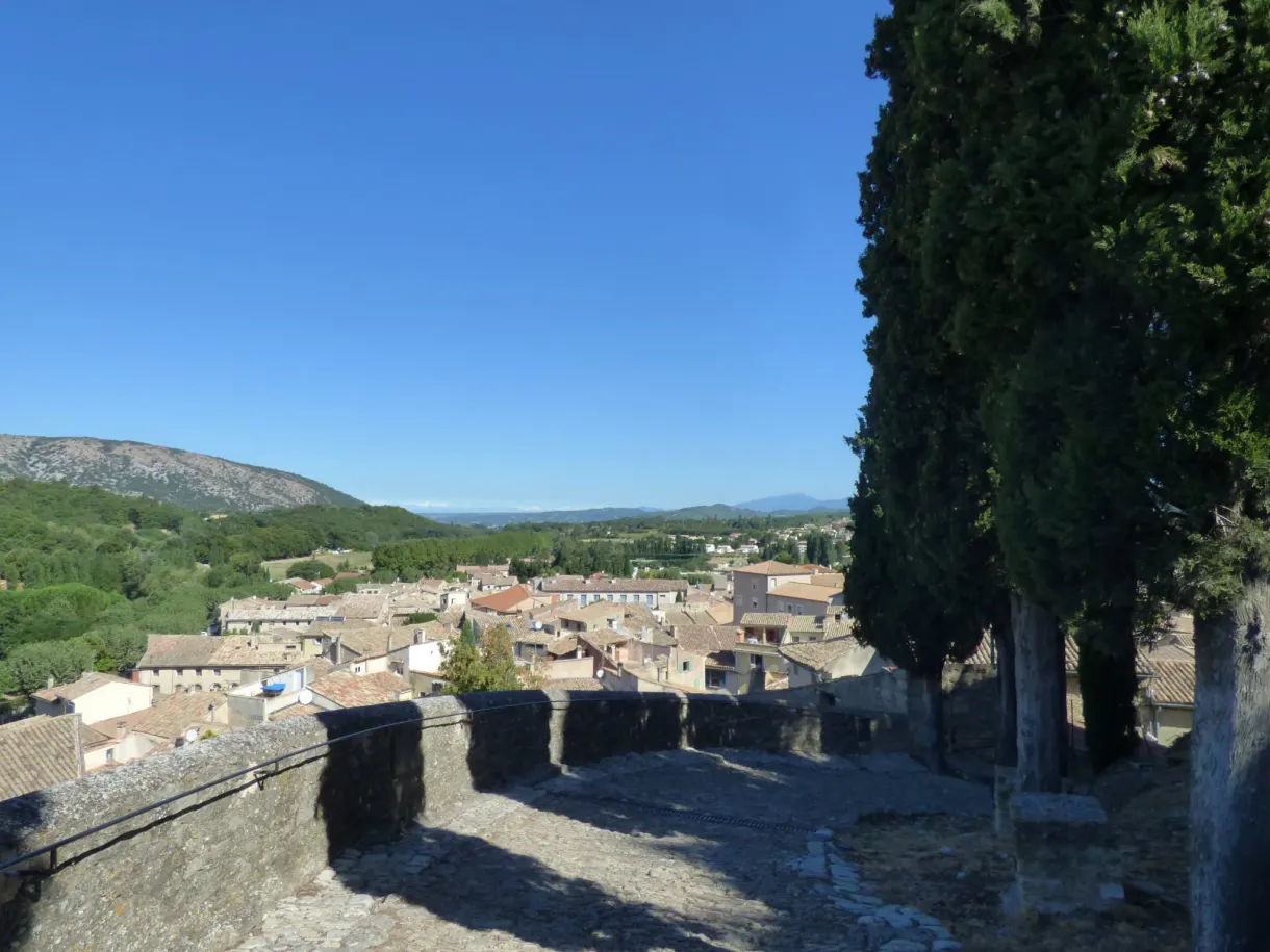 Terrasse dominant les toits du village, cyprès et sommets à l'horizon