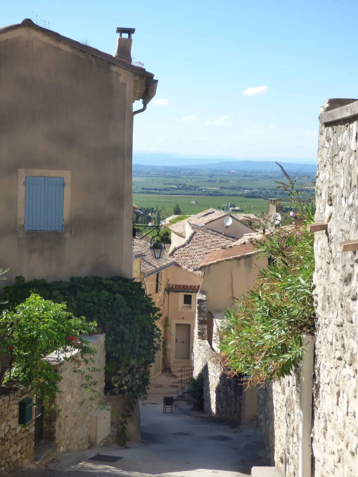 Ruelle étroite ouvrant sur la plaine entre deux façades