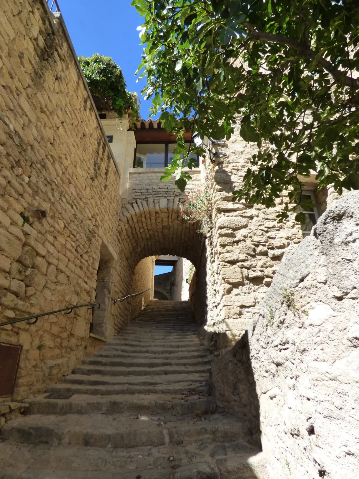 Escalier de pierre grimpant vers un passage voûté