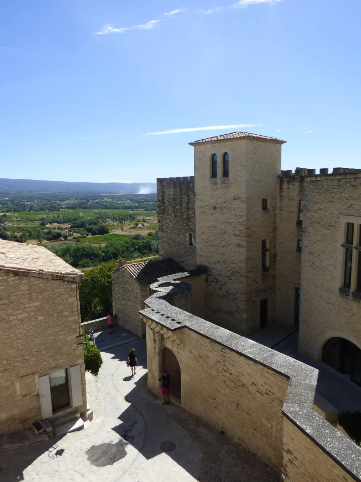 Bâtisse fortifiée et sa tour au bord de la rue en pente