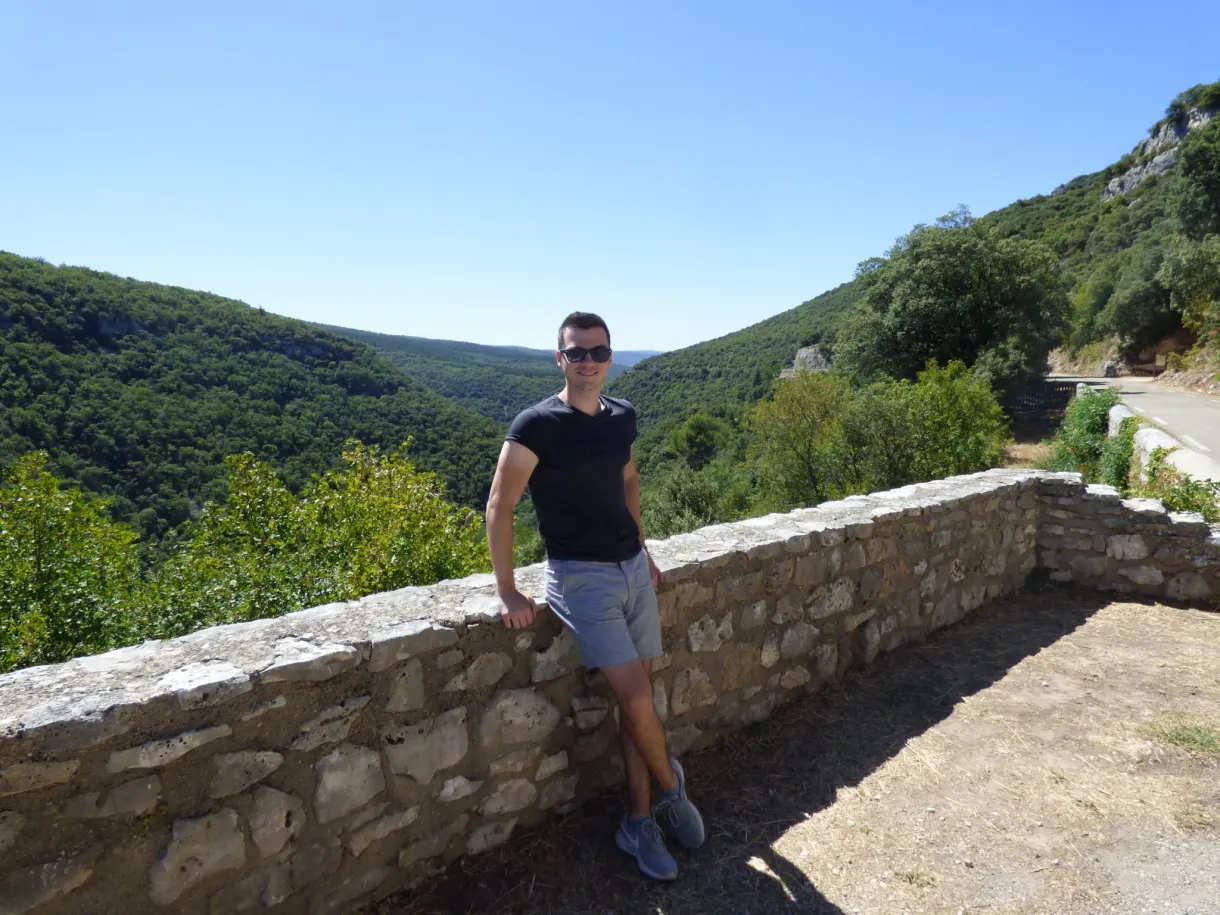 Homme adossé au muret d'un belvédère au-dessus du canyon