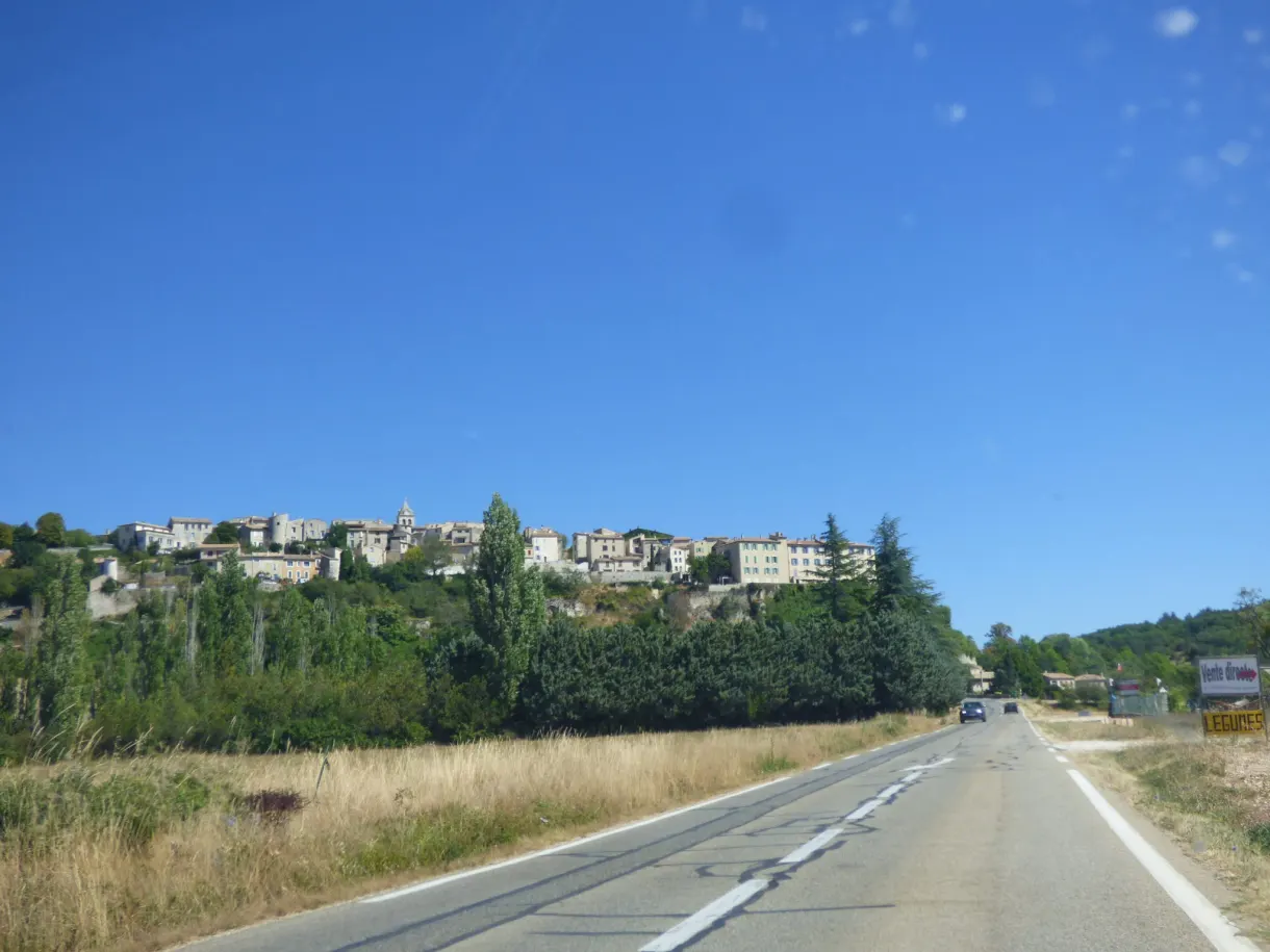 Village étiré sur sa crête au bout d'une route rectiligne