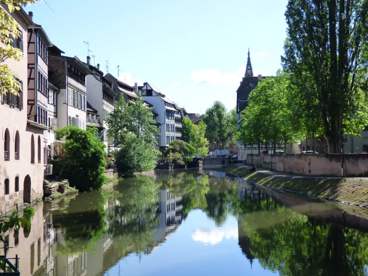 Canal bordé de maisons blanches, reflet parfait dans l'eau calme