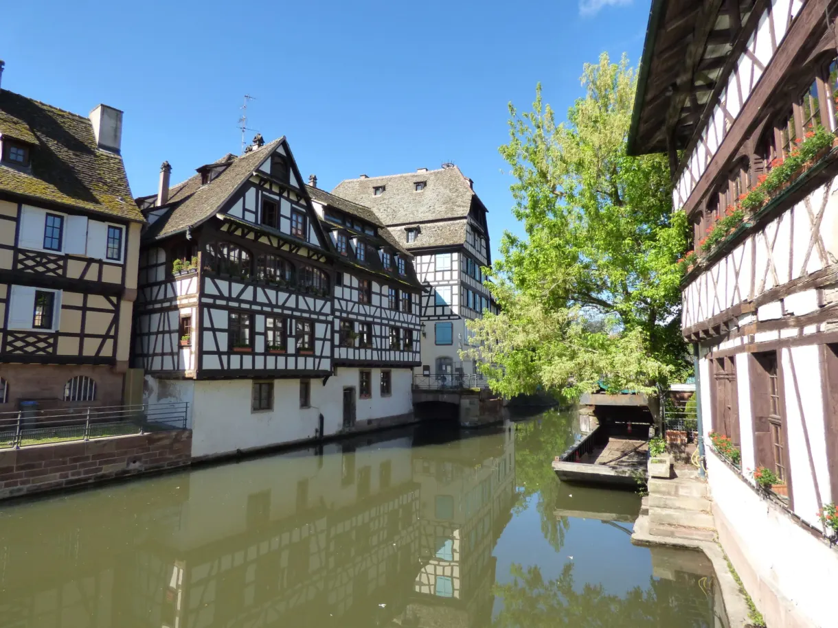 Maison à colombages sombre penchée au-dessus du canal étroit
