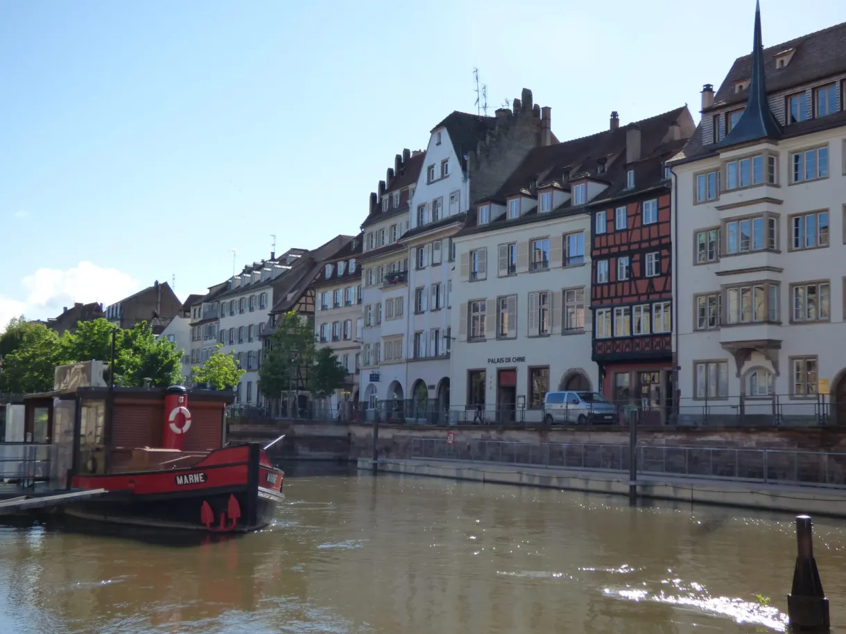Péniche rouge amarrée le long du quai aux façades claires