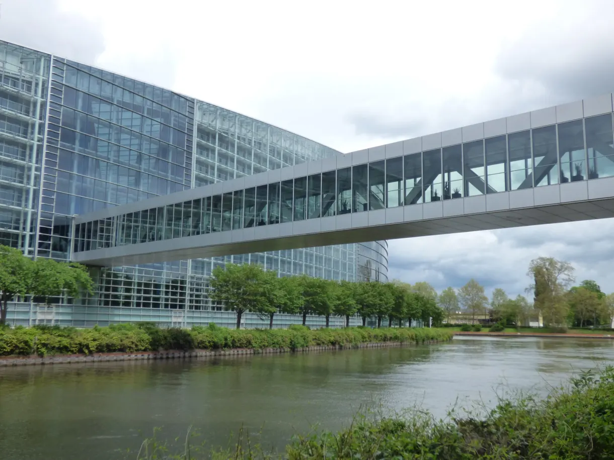 Passerelle vitrée reliant deux ailes du bâtiment au-dessus de la berge