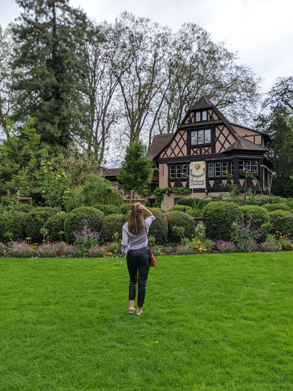 Voyageuse sur la pelouse devant un chalet à colombages