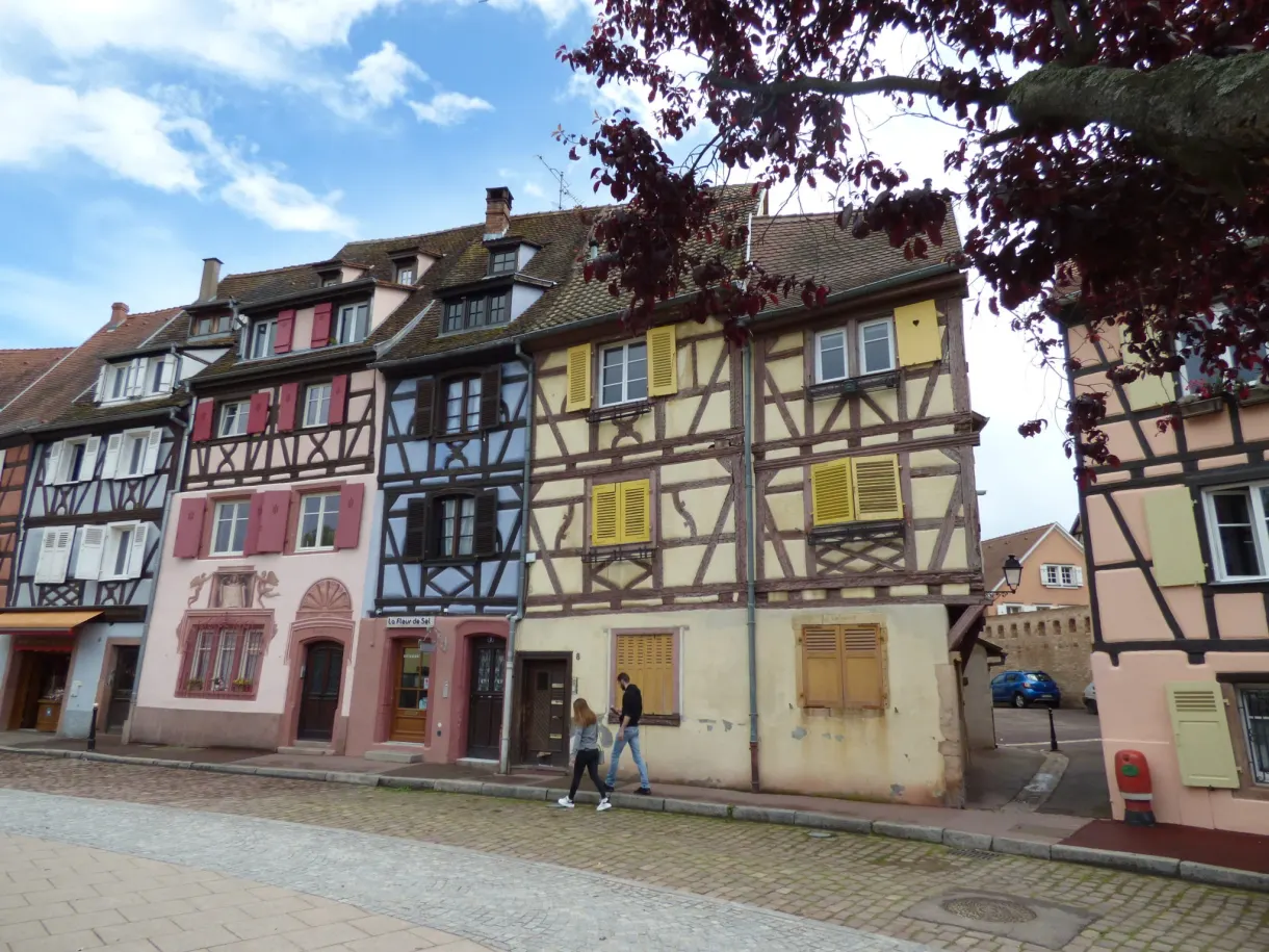 Maisons pastel à colombages bordant une place pavée