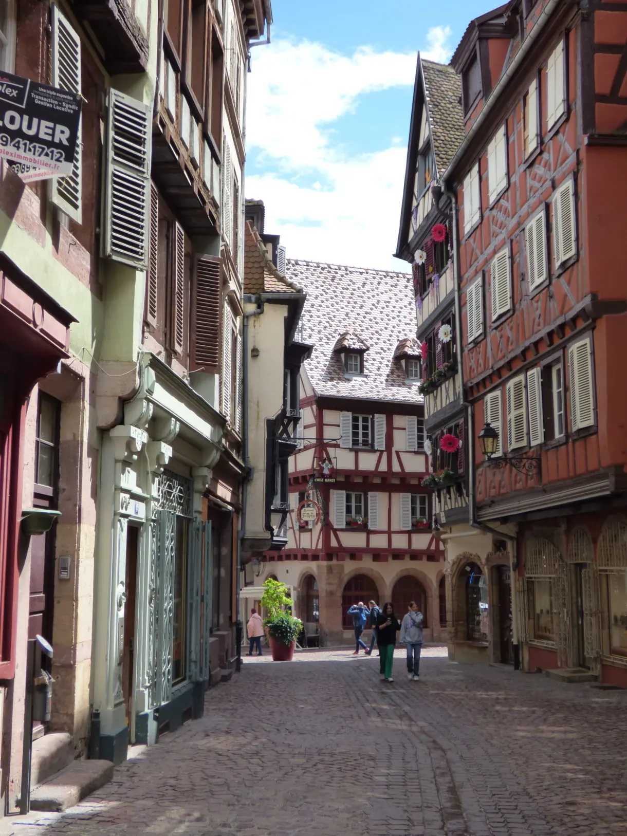 Ruelle pavée descendant entre des façades colorées
