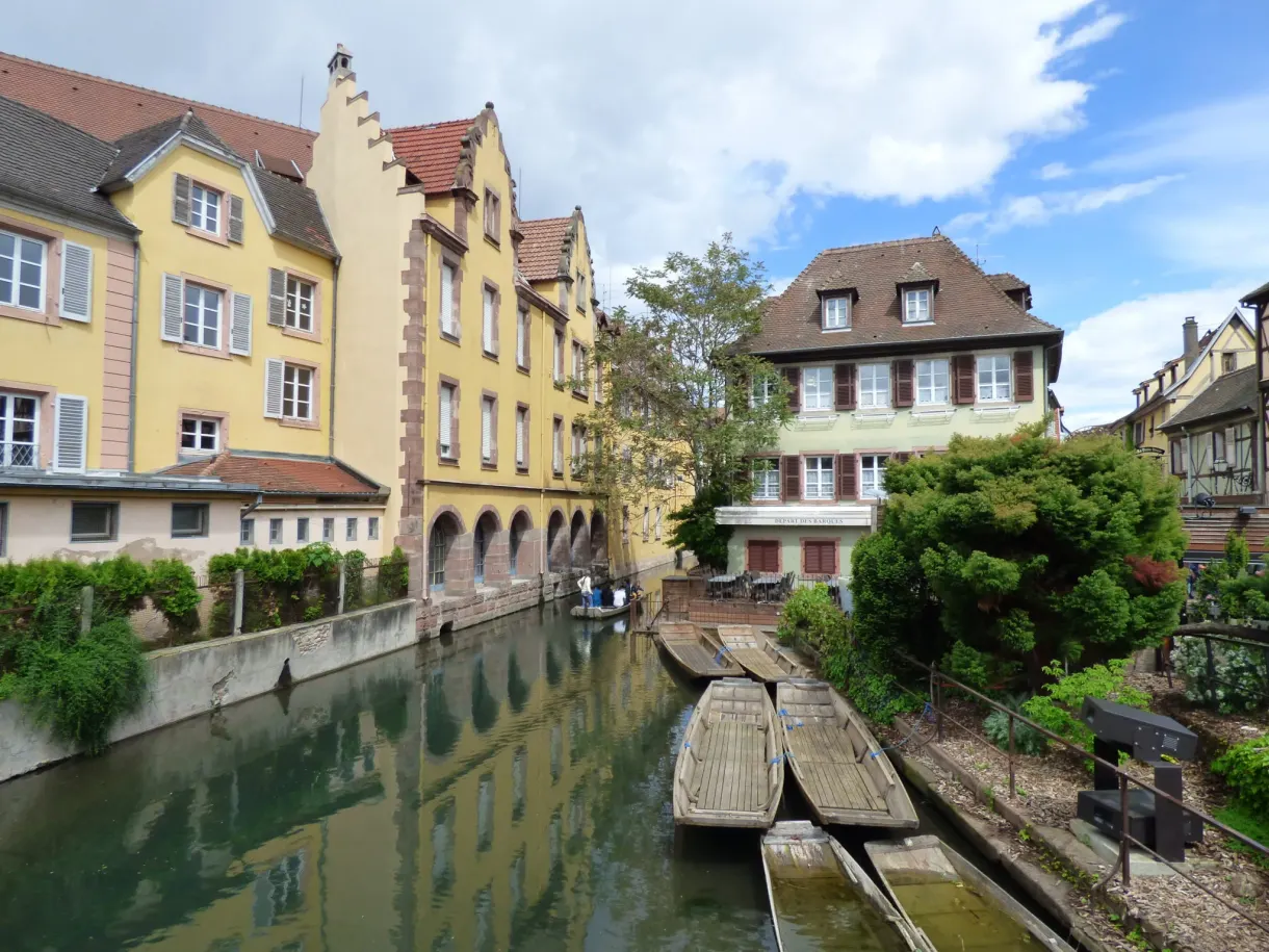 Maison jaune et barques amarrées au bout du canal