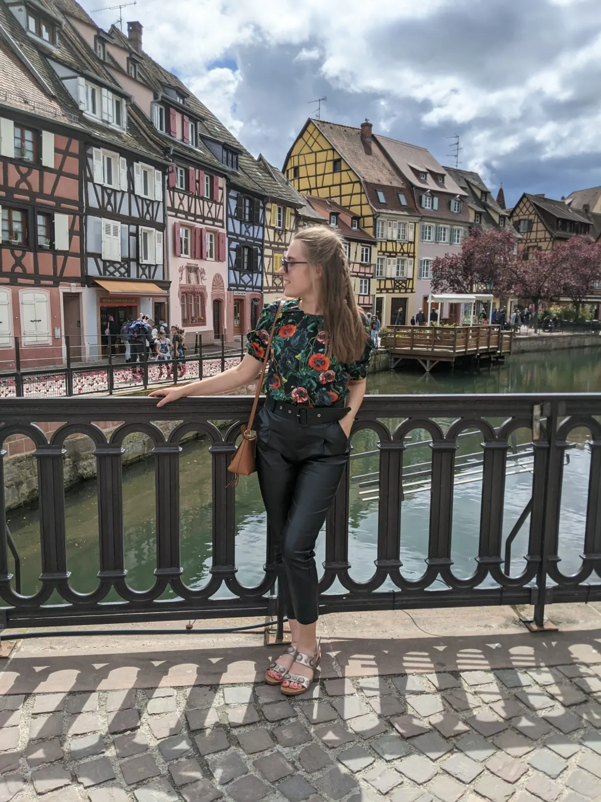 Voyageuse posant sur la passerelle devant les maisons colorées