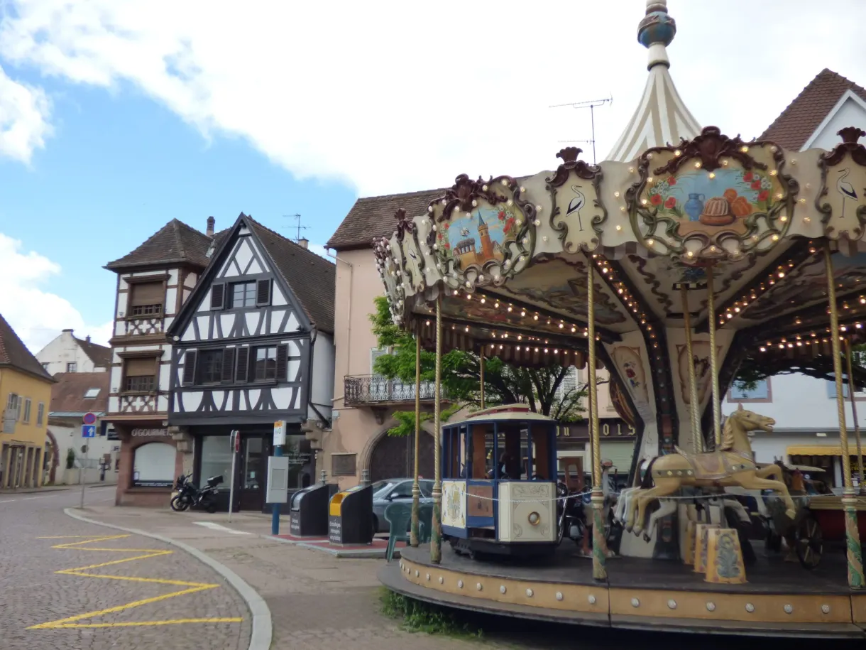 Manège ancien installé sur une place face aux vieilles maisons