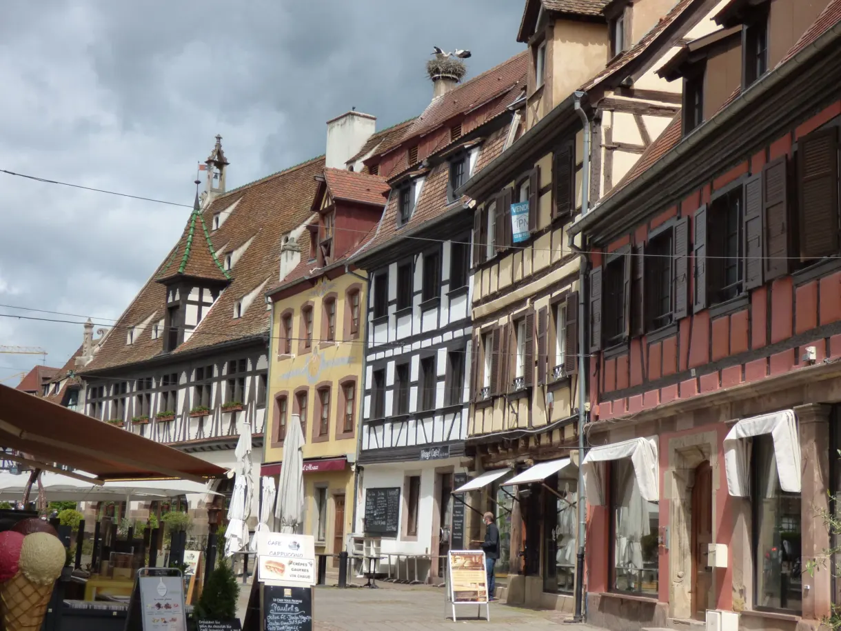 Rue piétonne avec terrasses et vitrines sous les façades anciennes