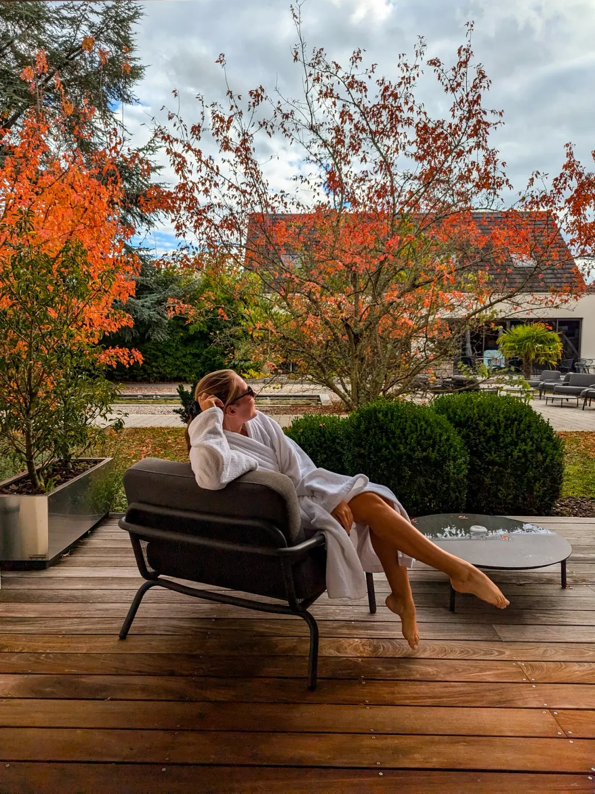 Marie en peignoir sur la terrasse de La Source des sens, hôtel spa en Alsace, en automne