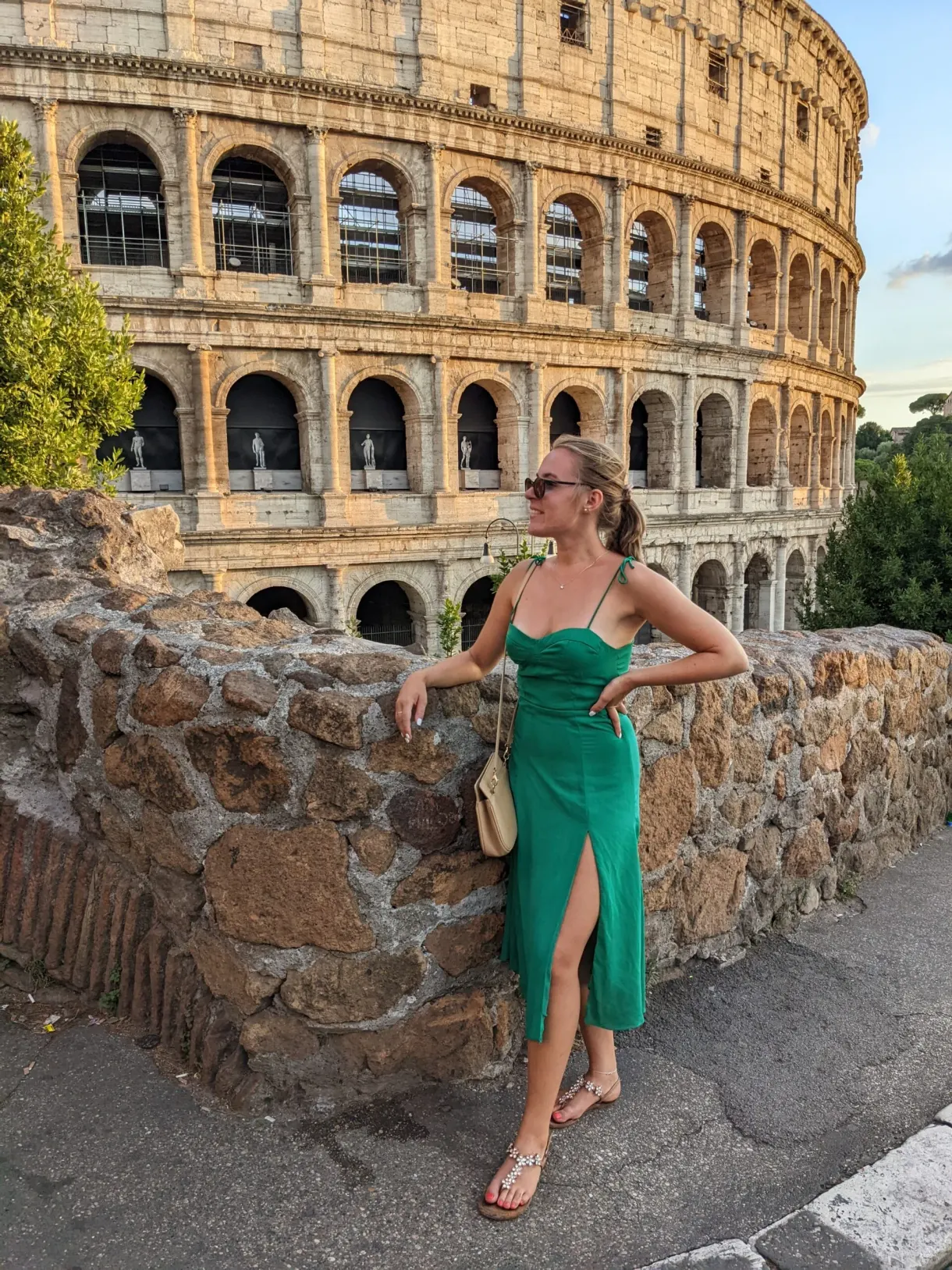 Femme en robe verte adossée à un muret face au monument