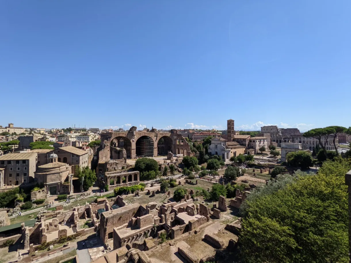 Champ de ruines s'étirant jusqu'au Colisée à l'horizon