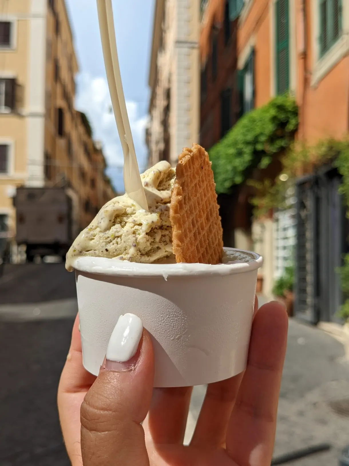 Glace claire et gaufrette brandies devant des façades colorées