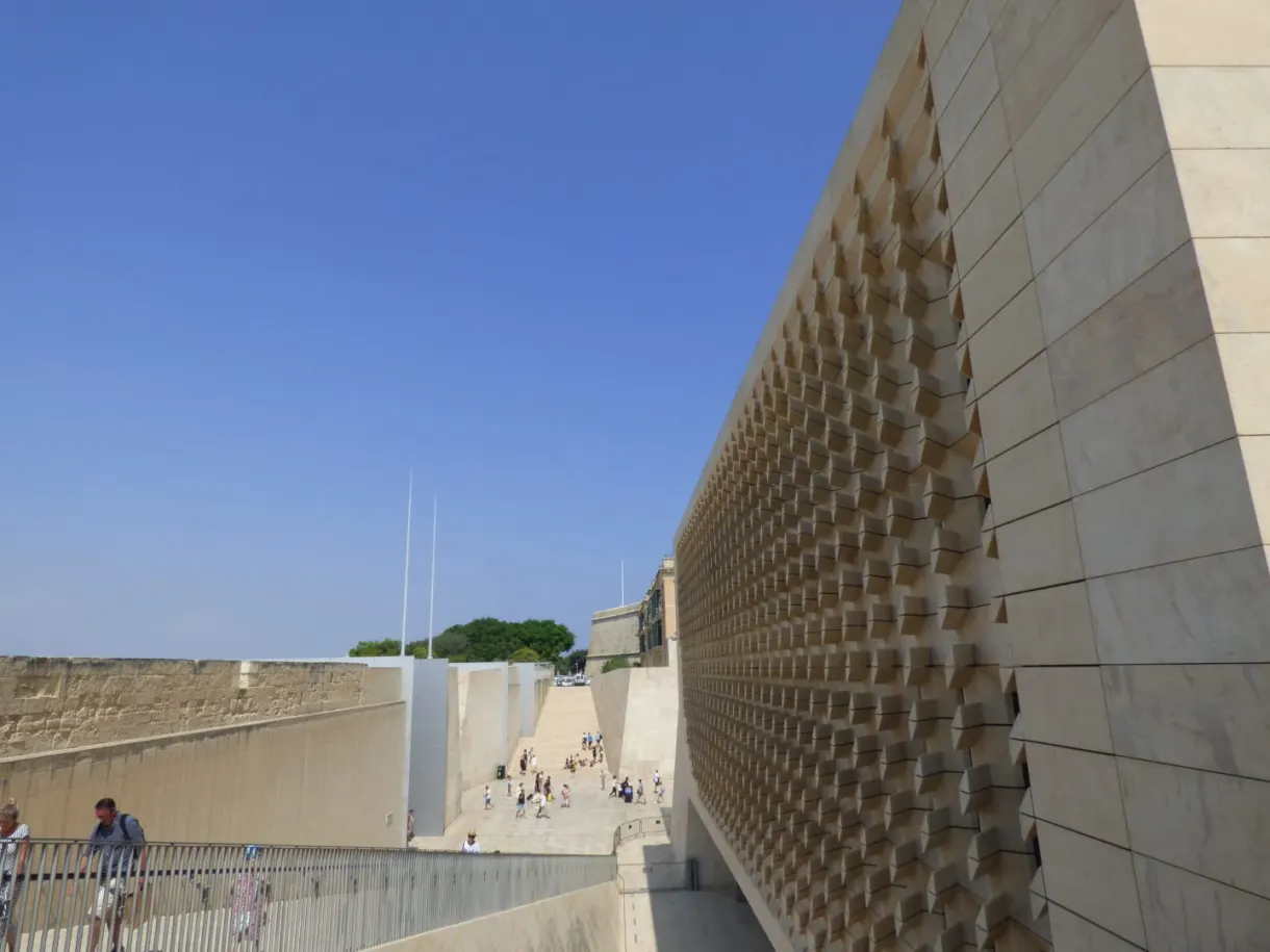 Façade de pierre ajourée d'un bâtiment contemporain sous le ciel bleu