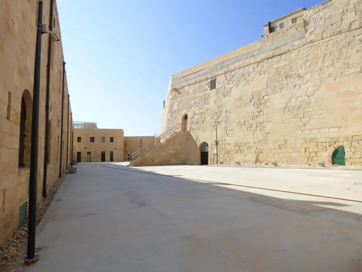 Cour vide entre les hauts murs de pierre