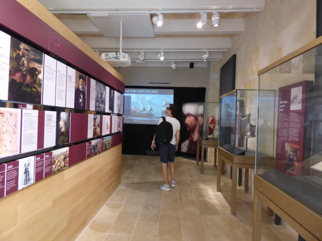 Visiteur devant les panneaux rouges de l'exposition du musée