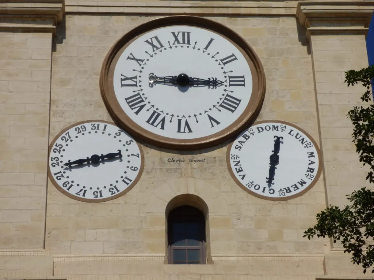 Horloge à trois cadrans sur le clocher de pierre