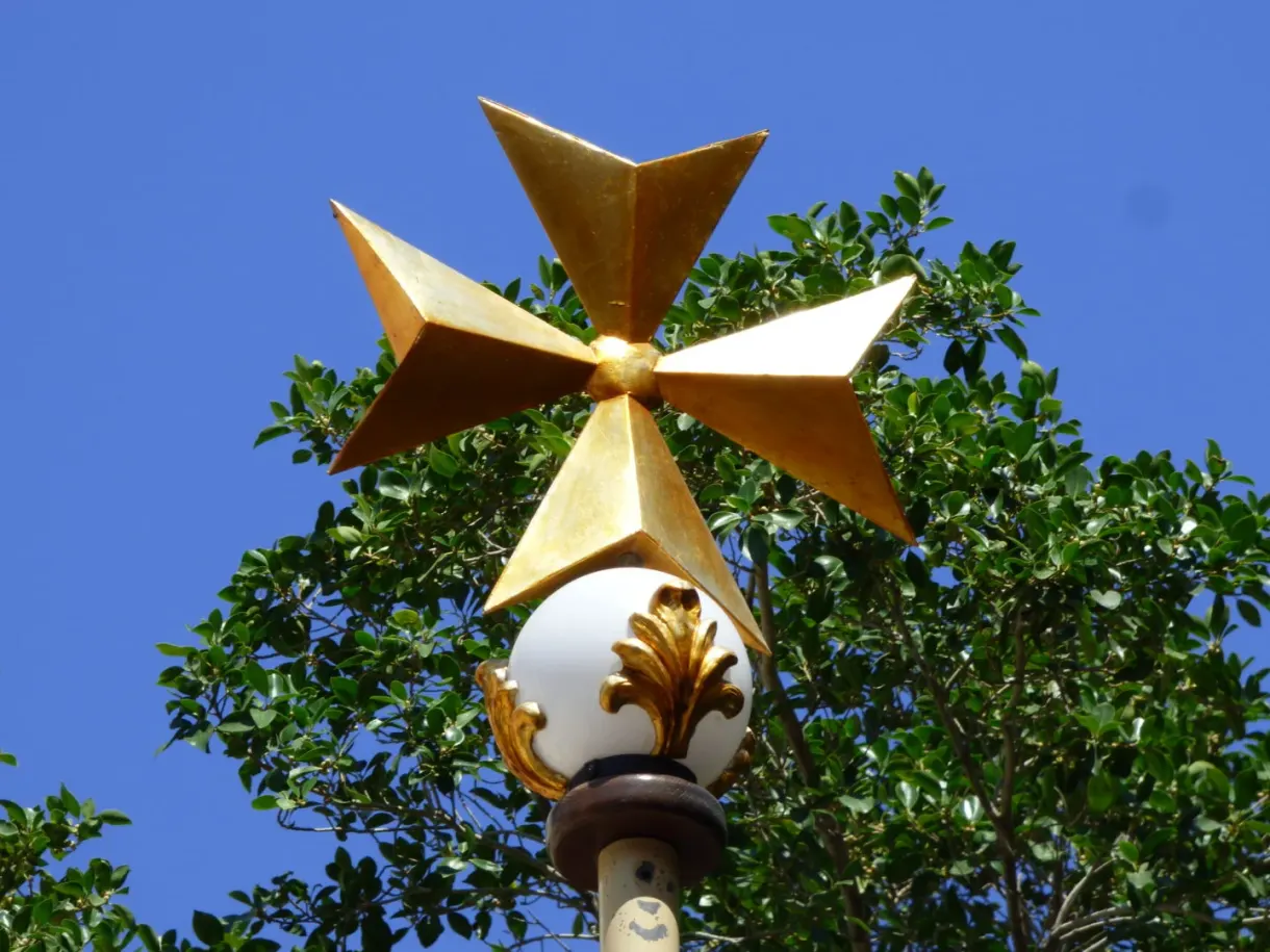 Croix de Malte dorée au sommet d'un lampadaire