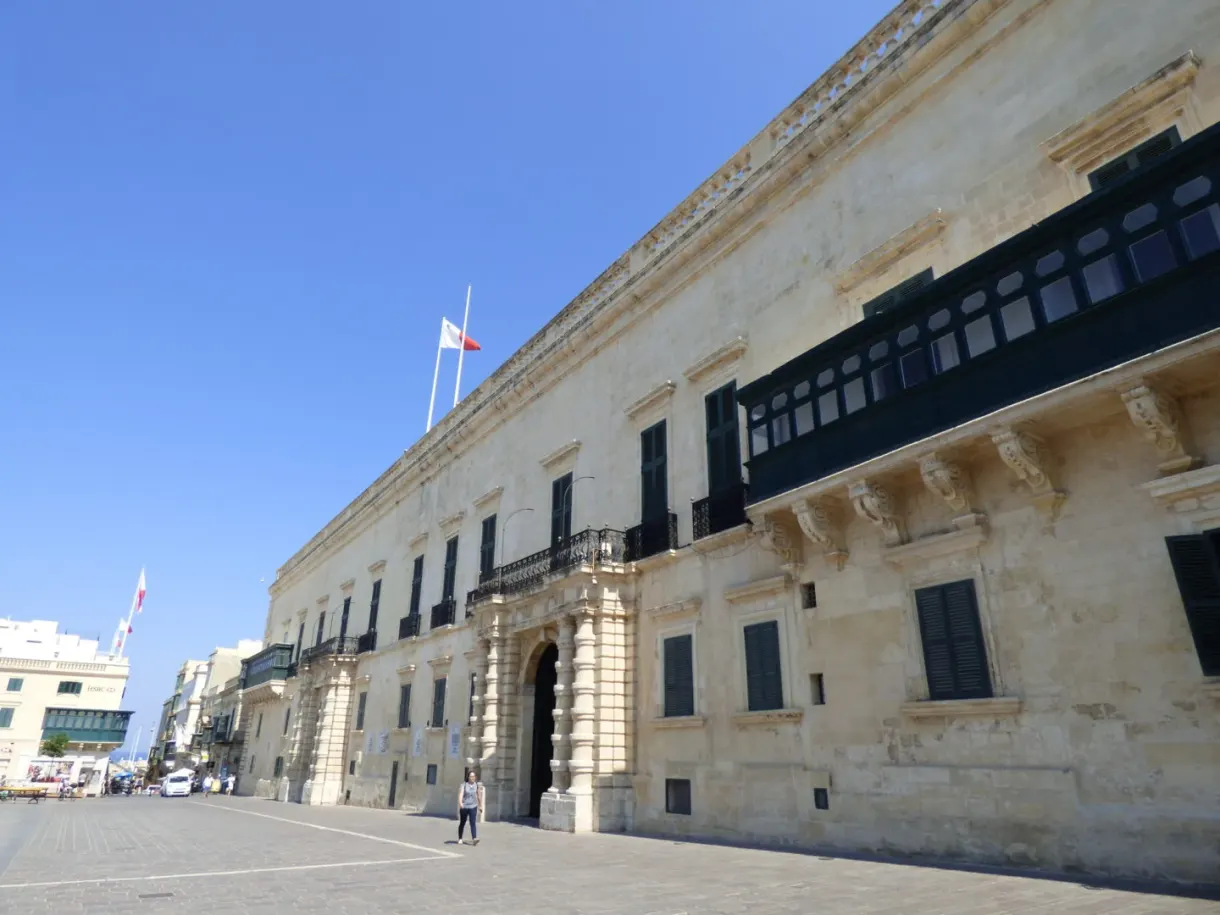 Longue façade du palais et ses balcons noirs sur la place