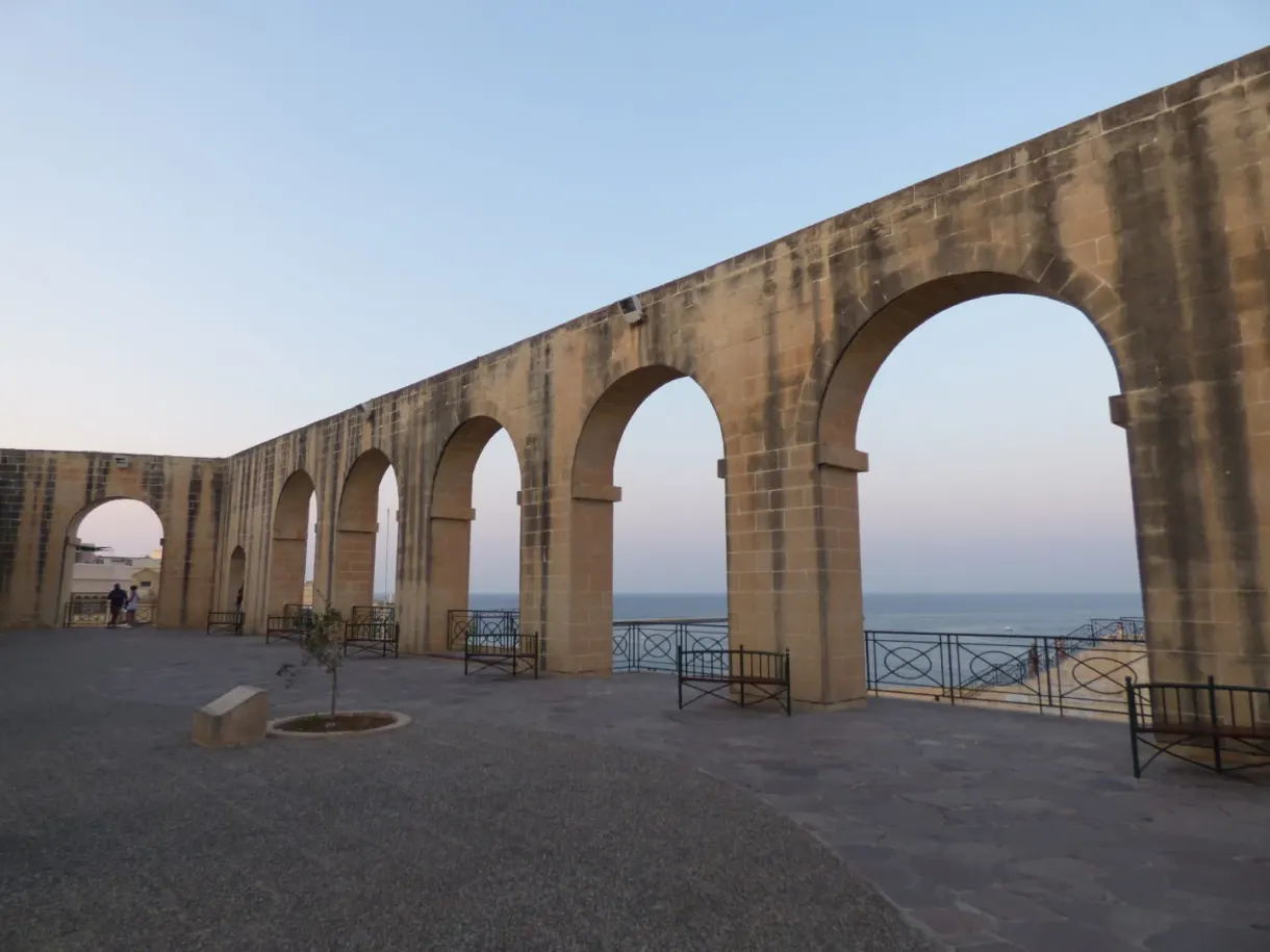 Longue arcade de pierre ouverte sur la mer en fin de journée