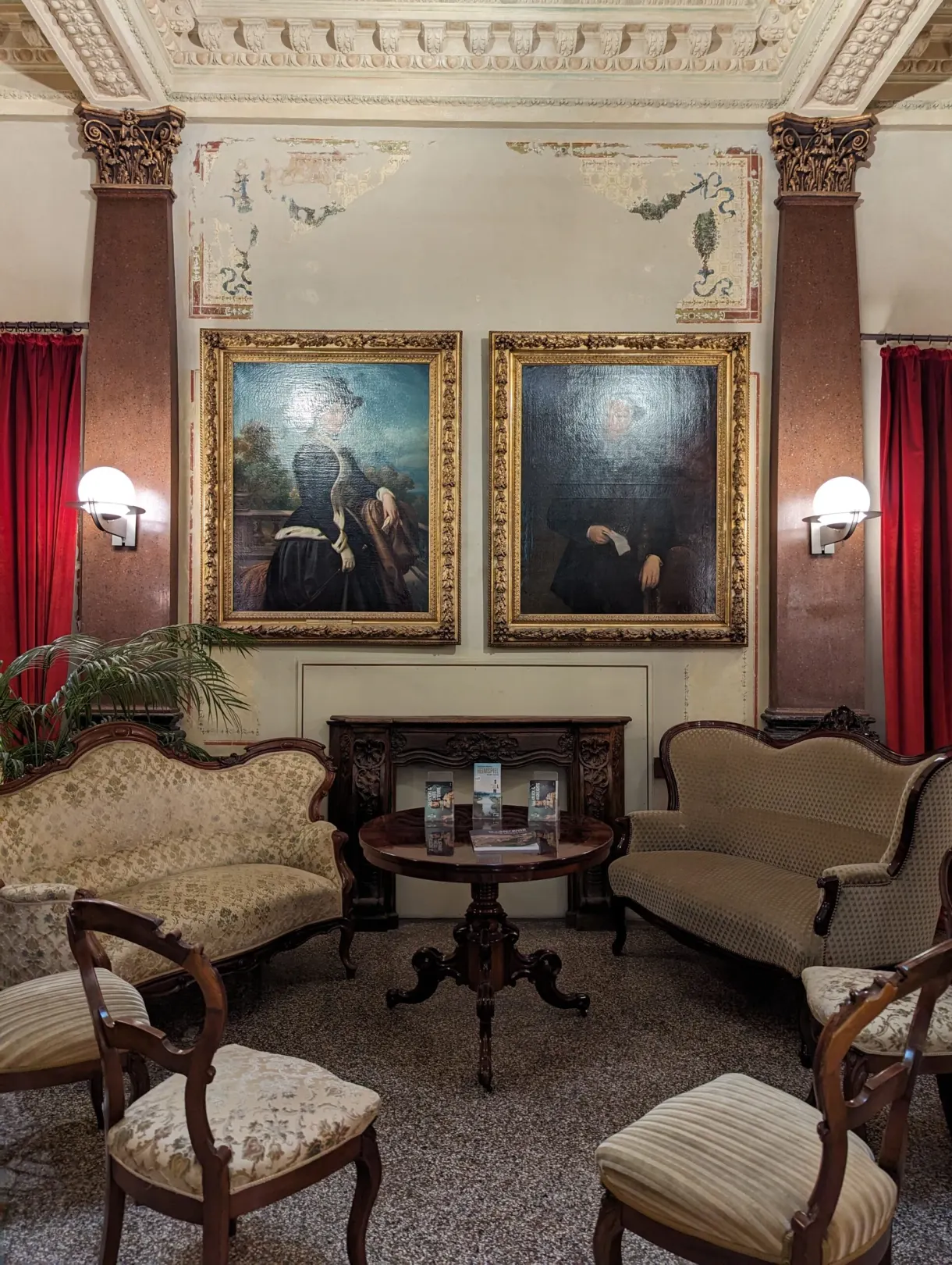 pièce d'époque dans un musée d'art avec des tableaux et des fauteuils anciens